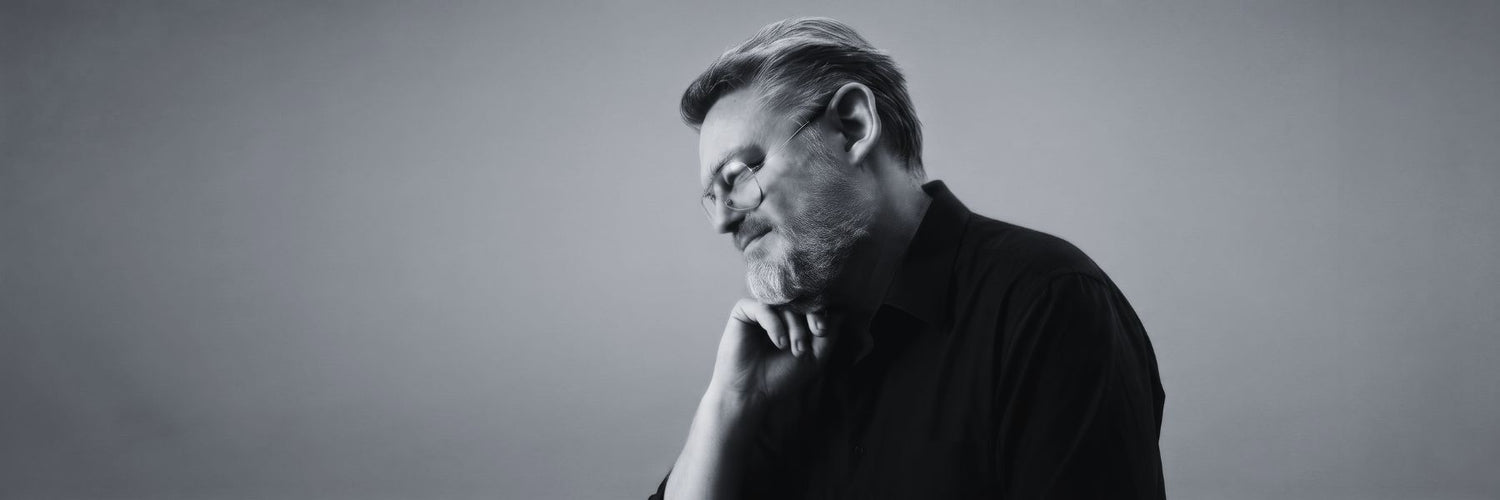 JFK Løvlien in a noir black-and-white portrait — the news and articles page of the Luxe Noir thriller author.